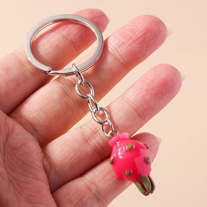 Detailed close-up of a dragon fruit pendant keychain with pink resin and silver ring