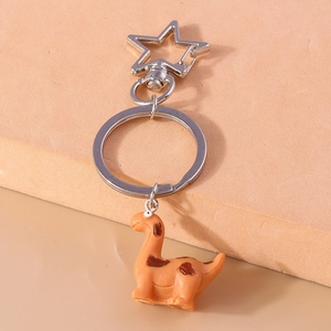 Close-up of orange dinosaur keychain with star-shaped clasp and silver metal rings