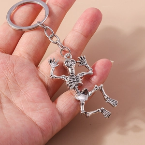 Gothic style skeleton keychain in vintage silver alloy finish held by hand