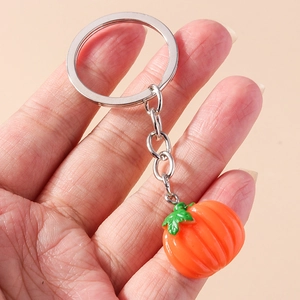 Macro shot of a handmade 3D resin pumpkin keychain with vibrant orange details and metal ring