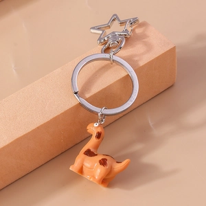 Detail of cute orange dinosaur keychain with silver star-shaped carabiner and ring