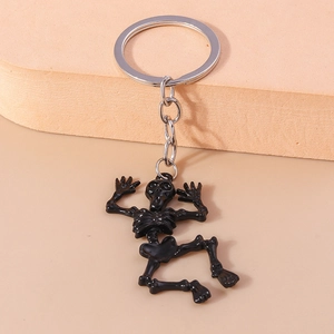 Detailed view of glossy black cartoon skeleton keychain with silver metallic ring