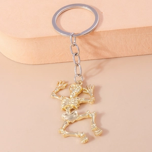 Detailed close-up of a golden metal skeleton keychain with a silver circular ring