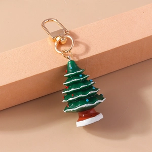Primer plano de un llavero de árbol de Navidad en resina verde con un cierre dorado fino
