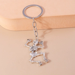 Detailed close-up of a silver skeleton keychain with a dancing skull pendant for bags