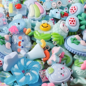 Macro view of colorful resin charms featuring fruit and heart shapes with metal loops