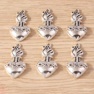 Set of retro silver heart crown pendants with sacred fire and thorn relief on wood background