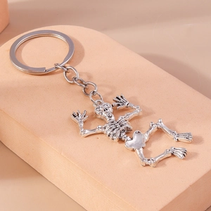 Close-up of a silver skull keychain with vintage finish on a minimalist display