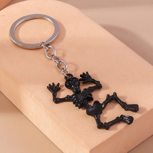 Macro detail of glossy black skull keychain with shiny silver metal ring and chain