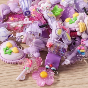 Close-up of assorted purple resin flower and heart charms with metal loops for DIY jewelry