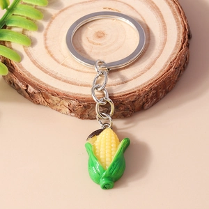 Detail view of realistic 3D corn keychain on wooden slice background with green plants