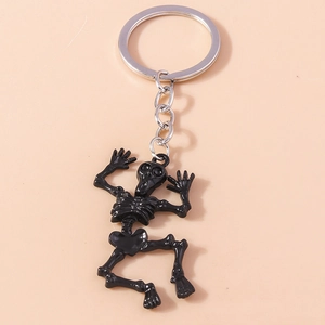 Detail of creative black skeleton keychain with polished silver metal ring on pink background