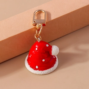 Detalle de llavero de gorro navideño con lunares rojos y cierre de metal dorado