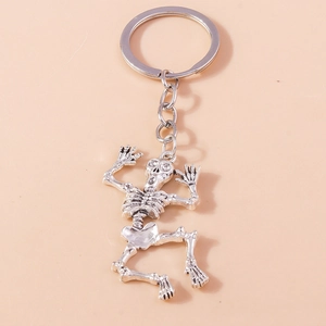 Detail view of vintage silver skeleton keychain with rhinestones and alloy metal texture