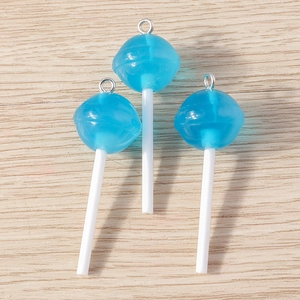 Dettaglio di ciondoli a lecca-lecca in resina blu traslucida con anelli metallici