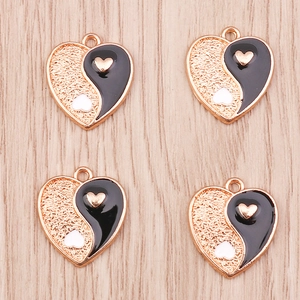 Detailed macro view of heart-shaped Yin Yang pendants with enamel and gold texture