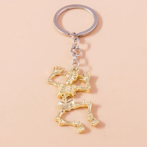 Macro detail of the golden dancing skeleton pendant with metallic finish on a keyring