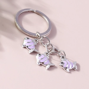 Détail de breloques carpes koi roses et violettes sur un porte-clés en métal argenté