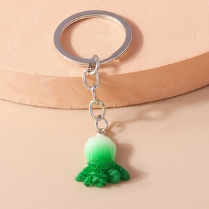 Detailed close-up of a resin cabbage keychain with silver ring on a pink display stand