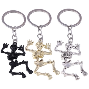 Three skeletal bone keychains in black, gold, and silver finishes on a white background