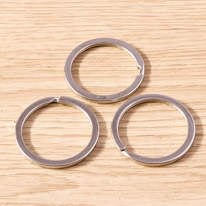 Three silver-plated alloy key rings on a wooden background for DIY jewelry making