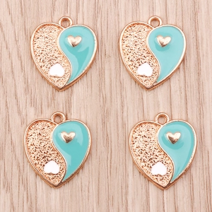 Close-up of four heart-shaped Yin Yang charms in light blue enamel and gold alloy