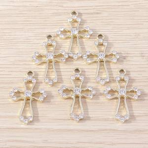 Close-up of golden hollow cross pendants with rhinestones for DIY jewelry making