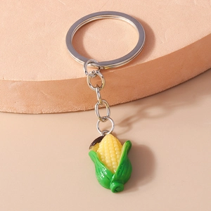 Detailed macro view of realistic resin corn keychain with yellow kernels and green leaves