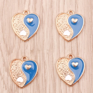 Detail of heart-shaped Yin Yang charms with blue enamel and gold finish for DIY jewelry