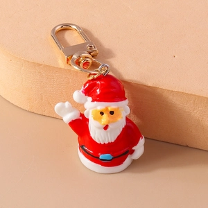 Detalle del llavero de Papá Noel en resina con cierre dorado sobre soporte de exhibición