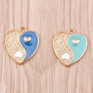 Detailed shot of heart-shaped Yin Yang pendants with blue and mint enamel inlay