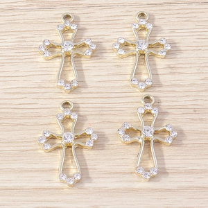 Detailed macro view of four golden rhinestone cross pendants on a wooden background
