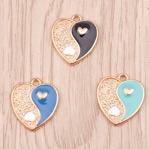 Macro detail of heart-shaped Yin Yang enamel charms in black and blue for DIY jewelry