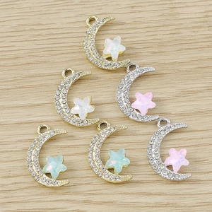 Detailed close-up of crescent moon charms with rhinestones and colorful star beads