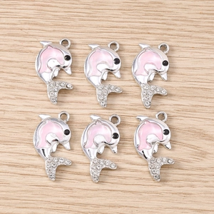 Dettaglio di sei ciondoli a forma di delfino in argento con smalto rosa e strass lucidi