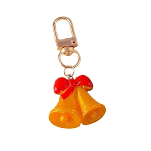 Llavero de Navidad con campanas doradas y lazo rojo sobre fondo blanco para accesorios