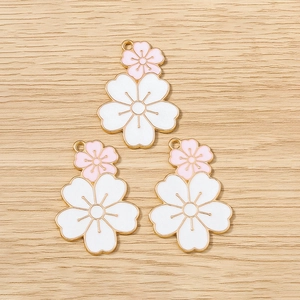 Detailed view of pink and white enamel cherry blossom flower charms for DIY jewelry