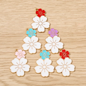 Detailed macro of flower pendant charms with colorful enamel finish and gold metal edges