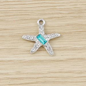 Detail of silver starfish pendant with blue gemstone and sparkling rhinestones