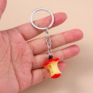 Creative realistic apple core keychain with red skin and silver metal link held in hand