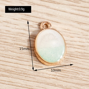 Détail d'un pendentif ovale DIY de 15 mm avec poids de 0,9 g sur fond en bois
