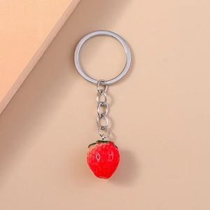 Close-up of realistic red strawberry pendant keychain with silver metal ring and chain