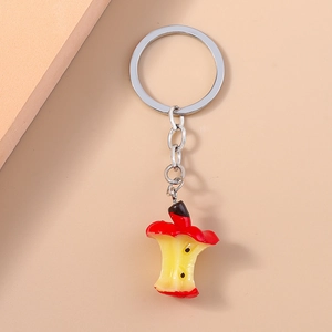 Detail shot of a realistic red apple core keychain with a silver metal ring and chain
