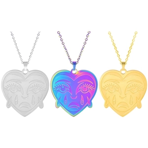 Detailed view of three heart shaped crying face necklaces in gold silver and rainbow finishes