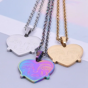 Detailed view of three heart-shaped crying face pendants in gold, silver, and rainbow steel