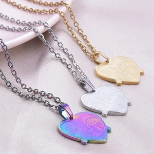 Macro detail of heart-shaped face pendants in gold and silver on silk background