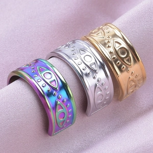 Detailed view of evil eye rings in rainbow, silver, and gold on purple satin