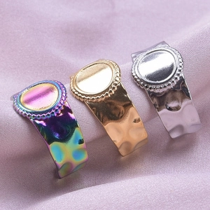 Detailed macro view of beaded edge oval rings with hammered texture in gold, silver, and rainbow