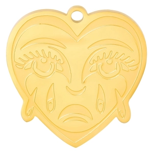 Detailed macro view of 18k gold plated heart pendant with sad face engraved detail