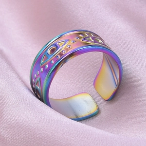 Macro shot of rainbow electroplated stainless steel Evil Eye ring on pink silk fabric